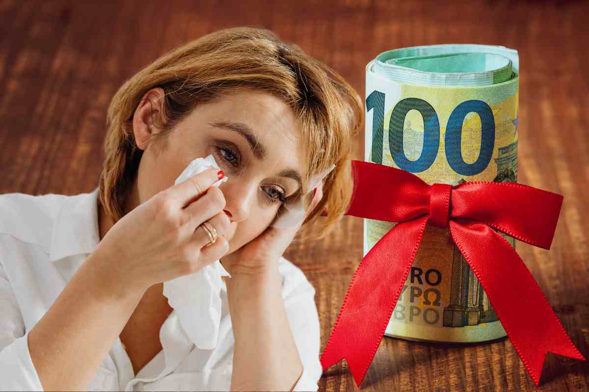Donna piange davanti a 100 euro con un fiocco rosso